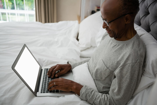 老年人在床上使用笔记本电脑