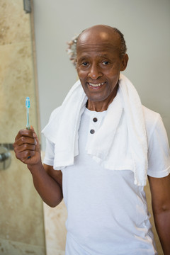 微笑的老人拿着牙刷靠墙的画像