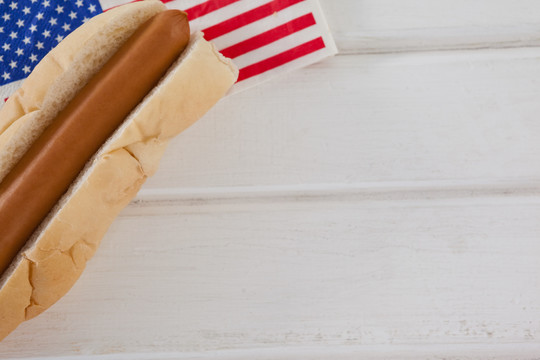 白木桌上的热狗和美国国旗