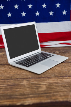 笔记本电脑和木桌上的美国国旗