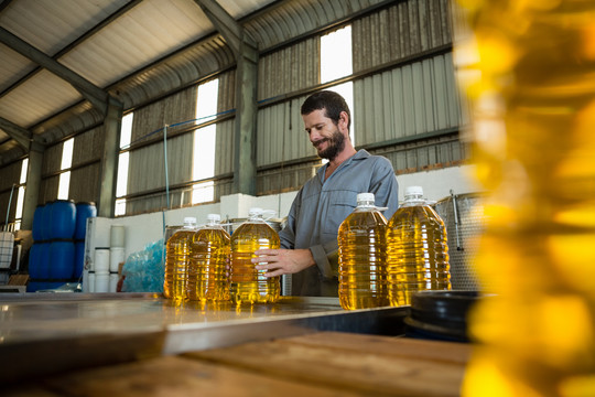 工人在工厂检查一罐橄榄油