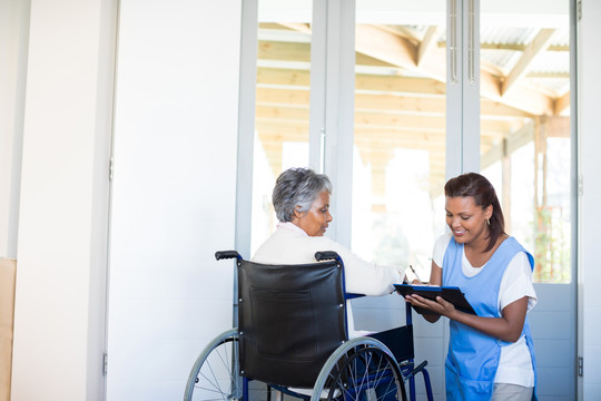 残疾老年妇女在家与女医生讨论