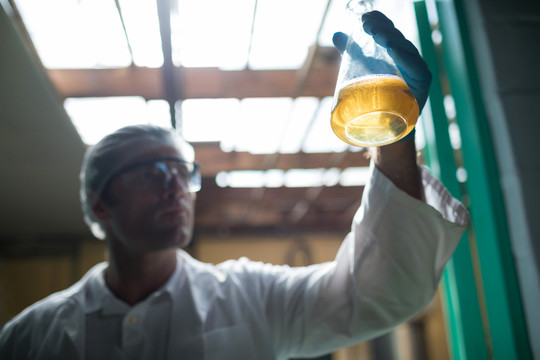 科学家在工厂用烧杯检验啤酒