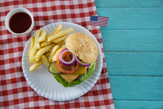 有美国国旗和炸薯条的芝士汉堡