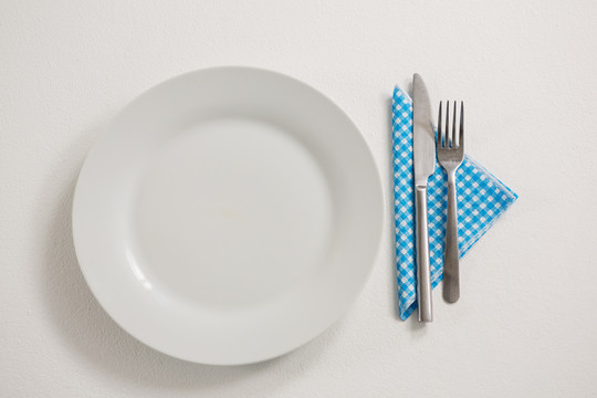 桌上有餐具和餐巾的盘子俯视图