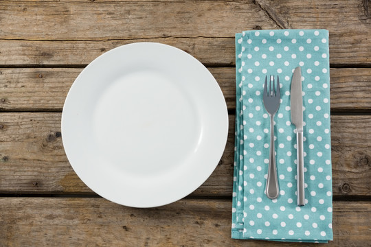 木桌餐巾纸空盘及餐具俯视图