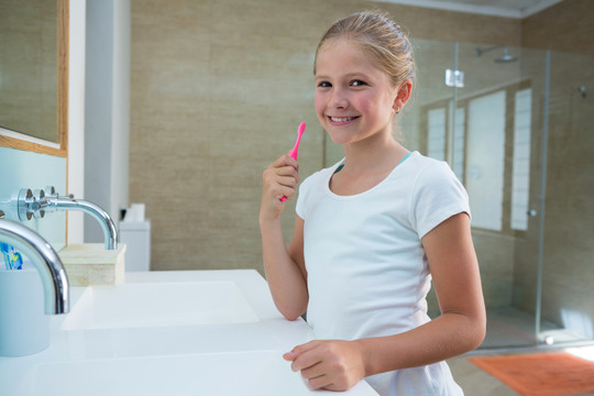 站在浴室刷牙的女孩的肖像