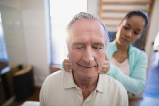 老年患者接受治疗师的颈部按摩
