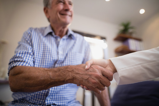 老年男性患者与女性治疗师握手