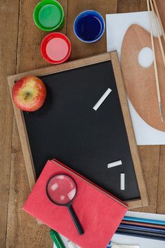 各种学校用品和木桌上的苹果