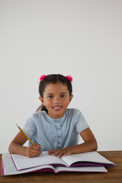 年轻女孩在白底书里写作