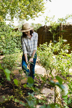 微笑的女人在花园里铲土