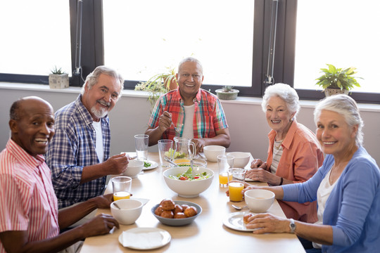 老年妇女和朋友一起吃早餐