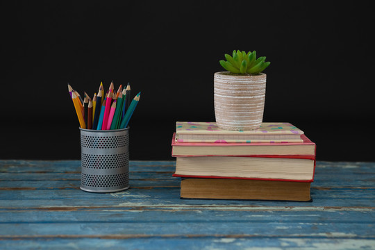 木桌上的彩色铅笔和书架