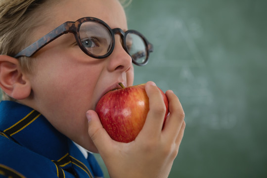 小学生在黑板上吃红苹果