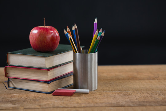 学校用品和书堆在上面放着红苹果