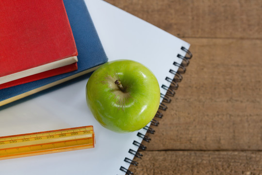 木桌上的青苹果和学校用品