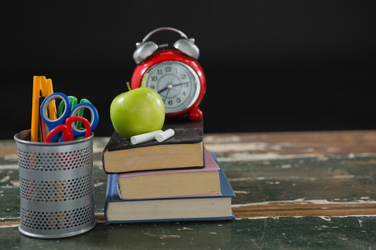 笔架的书堆上的苹果和粉笔