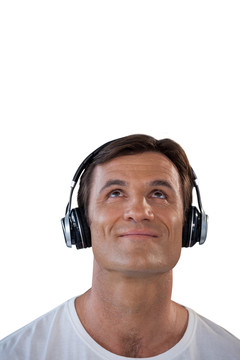微笑成熟的男人通过耳机听音乐