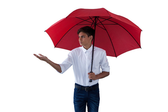 站在红色伞下的男孩