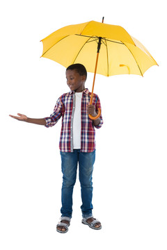 站在黄色伞下的男孩做手势