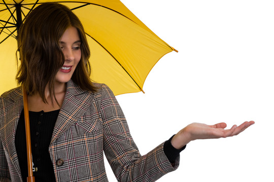 年轻女子一边打着伞一边做手势