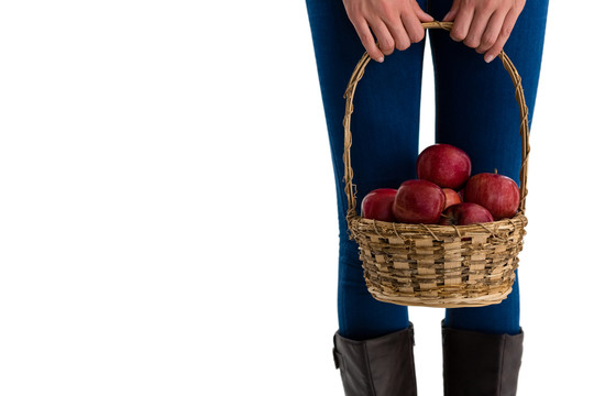 在柳条篮里拿苹果的女人