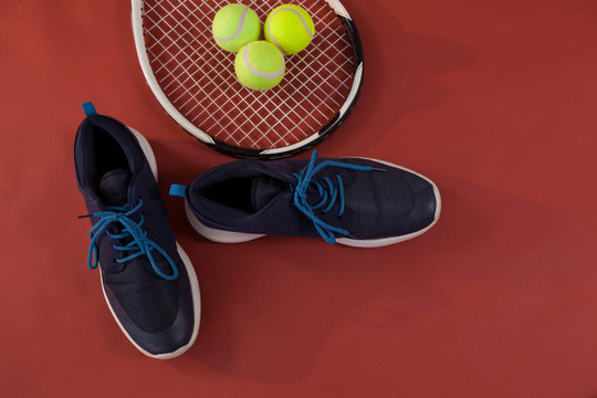 网球拍和球的蓝色运动鞋