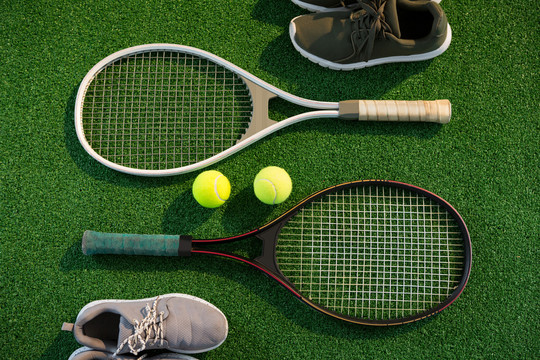 带球和运动鞋的网球拍