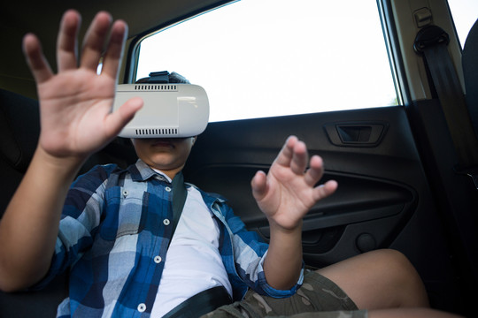 男孩在车上使用虚拟现实耳机