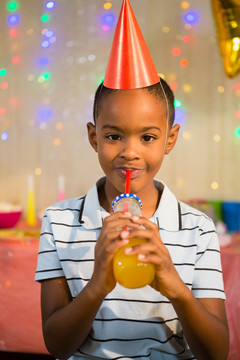 生日聚会上喝果汁的快乐男孩