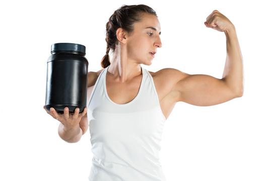 女运动员拿着补品罐时屈伸肌肉