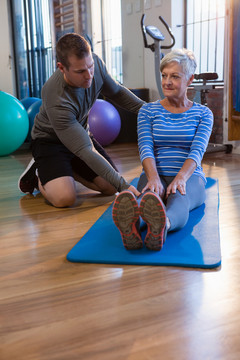 理疗师协助老年妇女锻炼