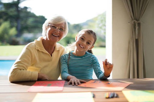 孙女和祖母在餐桌上画画