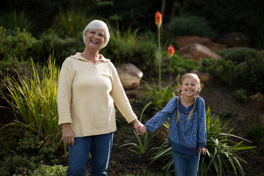 微笑的孙女和祖母站在花园里