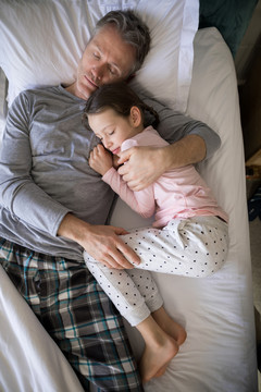 父亲和女儿睡在卧室的床上