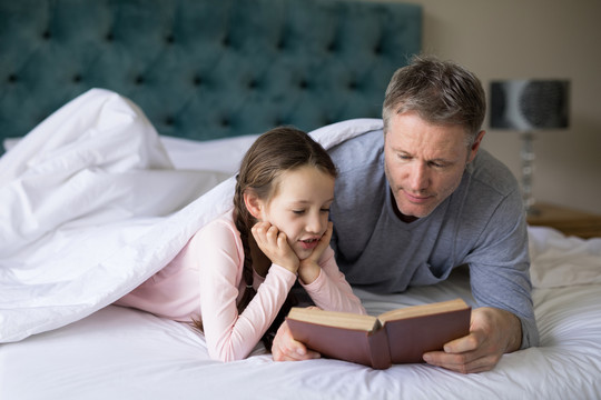 爸爸和女儿在床上看书