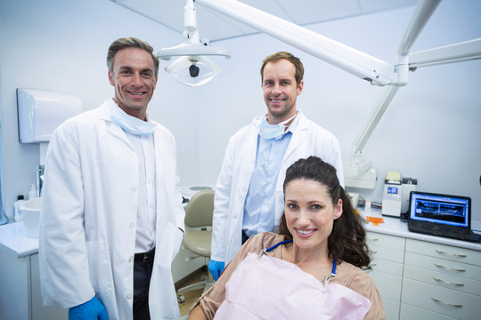 牙科诊所里微笑的患者和牙医