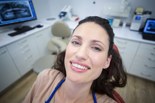 在牙医椅上微笑的女性患者