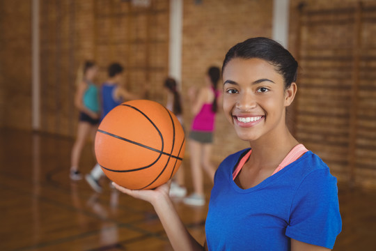 一幅高中女生在后台打篮球的照片