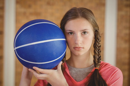 球场上抱着篮球的坚定女孩
