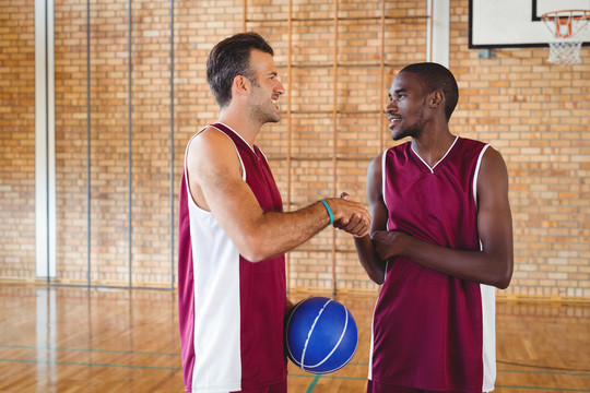 在球场上篮球运动员互相握手
