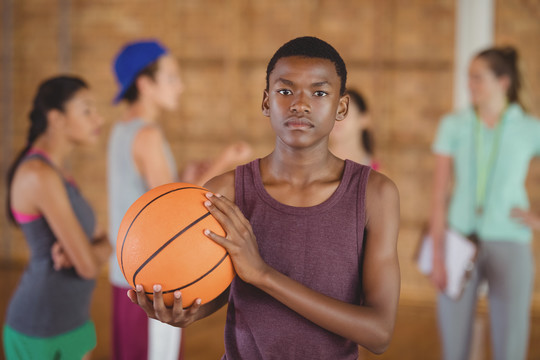 高中男孩站在球场上打篮球