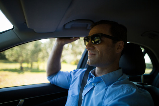 开车时戴太阳镜的男人