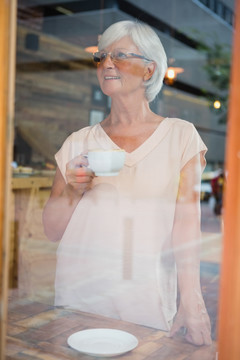 体贴的老年妇女喝咖啡