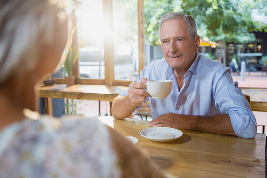 老年夫妇喝咖啡时相互交流