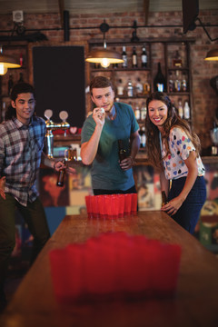 一群朋友在酒吧玩啤酒乒乓球游戏