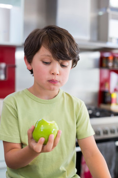 家里厨房里拿苹果的男孩