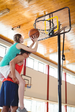 男子在球场打篮球时背着女朋友
