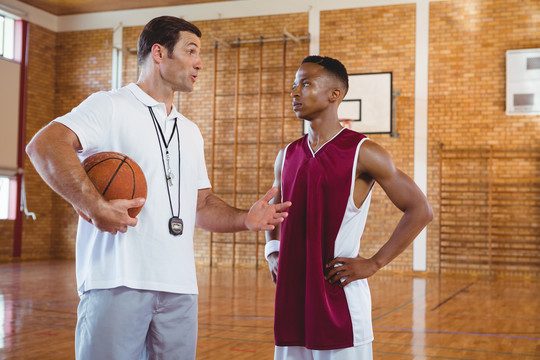 站在球场上指导篮球运动员的教练